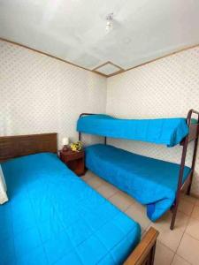 2 Etagenbetten in einem Zimmer mit blauer Bettwäsche in der Unterkunft Cabañas Pino, Un lindo lugar de descanso -playa I in Las Cruces