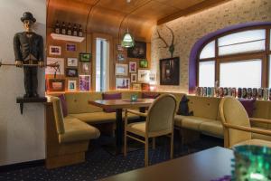 un ristorante con tavolo, sedie e statua di Hotel Pension Kirchplatz a Sankt Anton am Arlberg