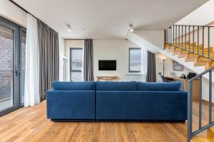 a blue couch in a living room with a staircase at Gudauri Lodge in Gudauri