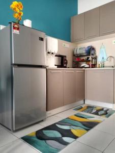 eine Küche mit einem Kühlschrank aus Edelstahl und einem farbenfrohen Teppich in der Unterkunft H&H Lovely Homestay in Nilai (Residensi Lili) in Nilai