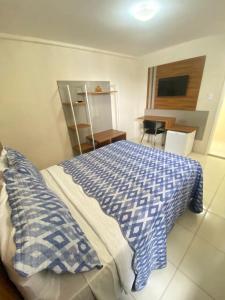 a bedroom with a bed with a blue and white blanket at Avelan Plaza Hotel in Nossa Senhora da Glória