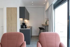 two pink chairs in a room with a kitchen at Voda Luxury Residence Penthouse #601 in Athens