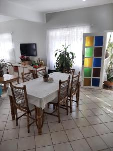 a dining room with a white table and chairs at Tartaruga Marinha Guest House in Ubatuba