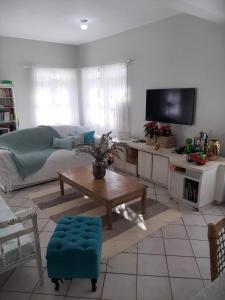 uma sala de estar com um sofá e uma mesa em Tartaruga Marinha Guest House em Ubatuba