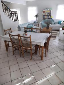 Tartaruga Marinha Guest House في أوباتوبا: غرفة معيشة مع طاولة وكراسي