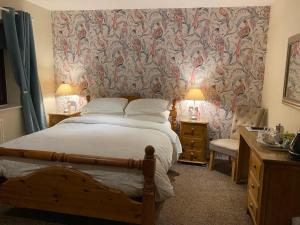 um quarto com uma cama grande e papel de parede em Laundimer House em Corby
