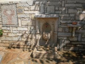 a stone wall with a stoneificialificialificialificialificialificialificialificialificialificial at Elli Studios & Apartments in Marathokampos