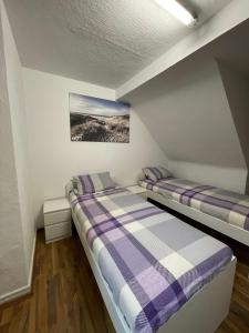 two beds in a room with white walls at Monteur Wohnung für 4 Personen in Oberhausen. in Oberhausen