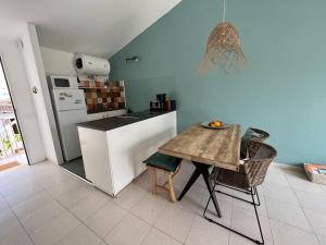 una cucina con tavolo, sedie e frigorifero di Lulu Menorca Modern apartment 300m from Cala Blanca beach a Cala Blanca