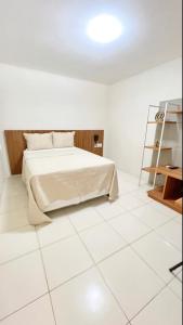 um quarto com uma cama e piso em azulejo branco em Avelan Plaza Hotel em Nossa Senhora da Glória