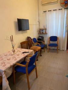a living room with a table and chairs and a tv at Gardenia Apartments in Pereybere