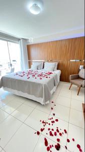 1 dormitorio con 1 cama con rosas rojas en el suelo en Avelan Plaza Hotel en Nossa Senhora da Glória