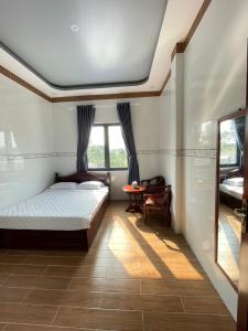 Nhà nghỉ Quỳnh Như في Cao Lãnh: غرفة نوم بسرير ونافذة