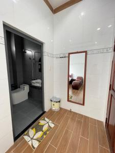 Nhà nghỉ Quỳnh Như في Cao Lãnh: حمام مع مرآة ومغسلة وحوض استحمام