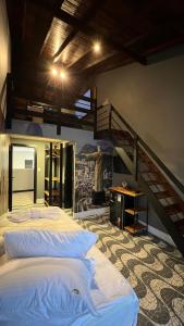 1 dormitorio con 2 camas y escalera en Hotel La Serena, en Maresias