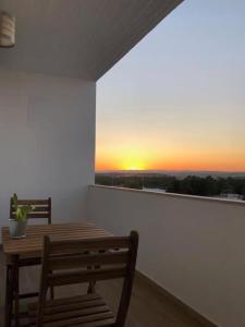 a room with a table and two chairs and a sunset at Apartamento T2 Montegordo a 500 m da praia in Monte Gordo
