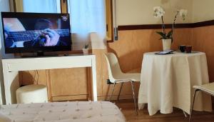 un soggiorno con TV e tavolo con tavolo e tavolo di Hotel San Felice a Bologna