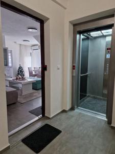 une chambre avec une porte en verre menant à un salon dans l'établissement Stan na dan - Brcko 1, à Brčko