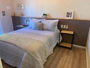 1 dormitorio con 1 cama grande y suelo de madera en Serra Bela Eco Pousada, en Urubici