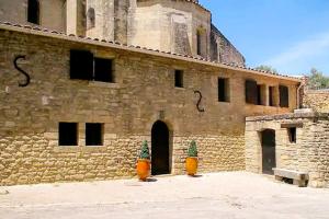 duży ceglany budynek z wieżą na górze w obiekcie Gite en Provence proche Avignon w mieście Sauveterre