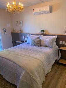 ウルビシにあるSerra Bela Eco Pousadaのベッドルーム1室(大型ベッド1台、シャンデリア付)