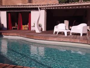 taras z leżakami i basen z wodą w obiekcie Gite en Provence proche Avignon w mieście Sauveterre