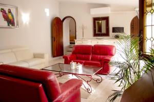 a living room with red couches and a table at Gite en Provence proche Avignon in Sauveterre