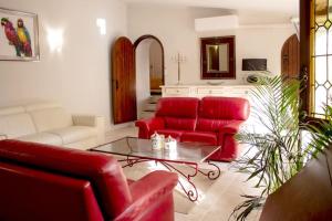 salon z czerwonymi kanapami i stołem w obiekcie Gite en Provence proche Avignon w mieście Sauveterre +25 zdjęć