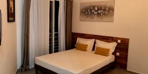 a bedroom with a bed with two yellow pillows at TSINGONI VILLAGE Meublé de Tourisme in Tsingoni