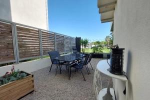 a patio with a table and chairs on a balcony at Escapade au Soleil B002 in Le Grau-du-Roi