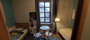 a small room with a table and chairs and a window at 25 Hours Hostel in Vilnius