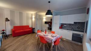 a living room with a table and a red couch at Agriturismo Tenuta Valletti. in Sesta Godano