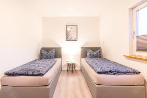 two twin beds in a room with a window at Haus Hanni Zarrentin am Schaalsee in Zarrentin