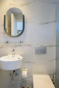 a white bathroom with a sink and a mirror at Hotel Papanikolaou in Ierissos