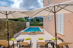 a patio with umbrellas and a swimming pool at Holiday Home Iva in Mlini