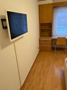 uma sala de estar com uma televisão de ecrã plano na parede em HoStel Self Check-In Solothurn em Zuchwil