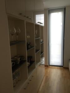 eine Küche mit weißen Schränken und einer Glasschiebetür in der Unterkunft Apartment Zwenkauer See in Zwenkau