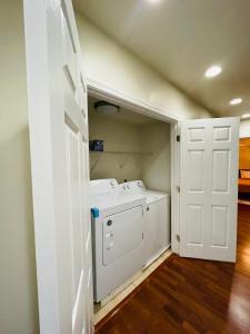 a washer and dryer in a laundry room with a door at Cozy home with rooftop deck-downtown baltimore in Baltimore