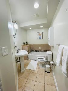 a bathroom with a tub and a toilet and a sink at Cozy home with rooftop deck-downtown baltimore in Baltimore
