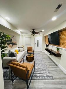 a living room with a couch and a flat screen tv at Cozy home with rooftop deck-downtown baltimore in Baltimore