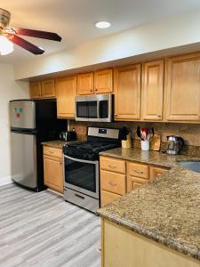 a kitchen with stainless steel appliances and wooden cabinets at Cozy home with rooftop deck-downtown baltimore in Baltimore