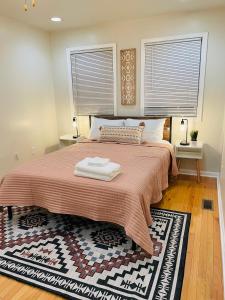 a bedroom with a large bed with two windows at Cozy home with rooftop deck-downtown baltimore in Baltimore