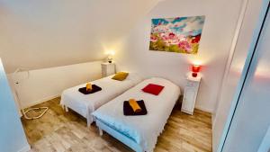 pokój z dwoma łóżkami i obrazem na ścianie w obiekcie Kerhos - appartement vue mer w mieście Camaret-sur-Mer