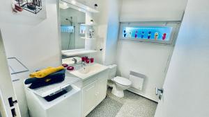 biała łazienka z umywalką i toaletą w obiekcie Kerhos - appartement vue mer w mieście Camaret-sur-Mer