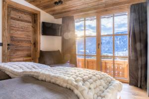 a bedroom with a large bed with a large window at Chalet Schintlbauer in Annaberg im Lammertal
