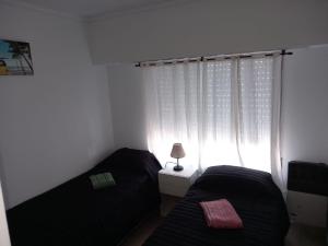 1 dormitorio con 2 camas frente a una ventana en Moderno y cómodo PH zona Aldrey/Materno en Mar del Plata