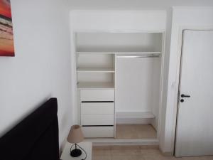un armario con estanterías blancas y una puerta de cristal en Moderno y cómodo PH zona Aldrey/Materno en Mar del Plata