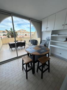 une cuisine avec une table et des chaises et un patio dans l'établissement Grand T2 proche de la mer, à Sète 21 autres photos