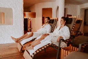 a man and a woman sitting in rocking chairs at Hotel Bergschlössl in Luson