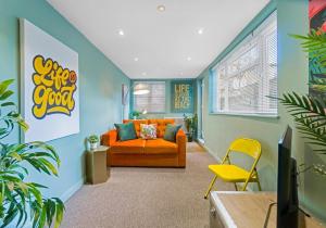 a living room with an orange couch and a yellow chair at Dorset Green Two By My Getaways in Brighton & Hove